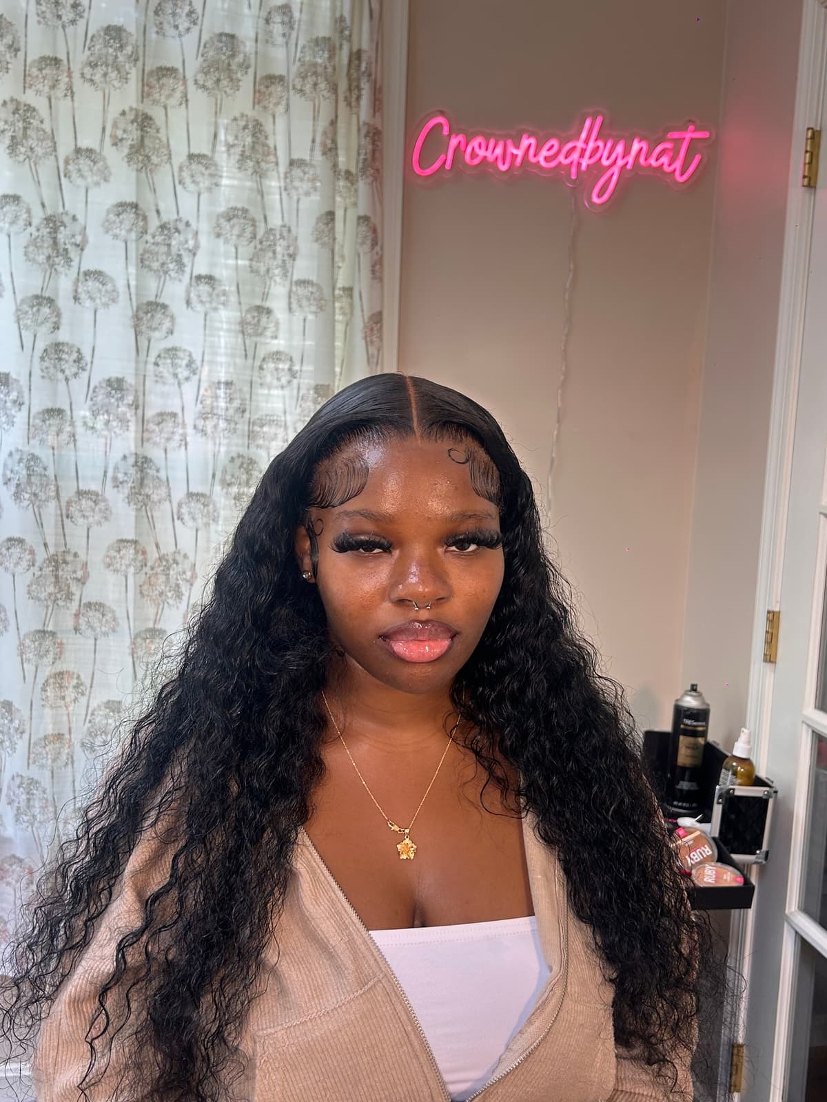 A long deep-wave install in natural black, centre parted, with the baby hairs swirled along a melted hairline