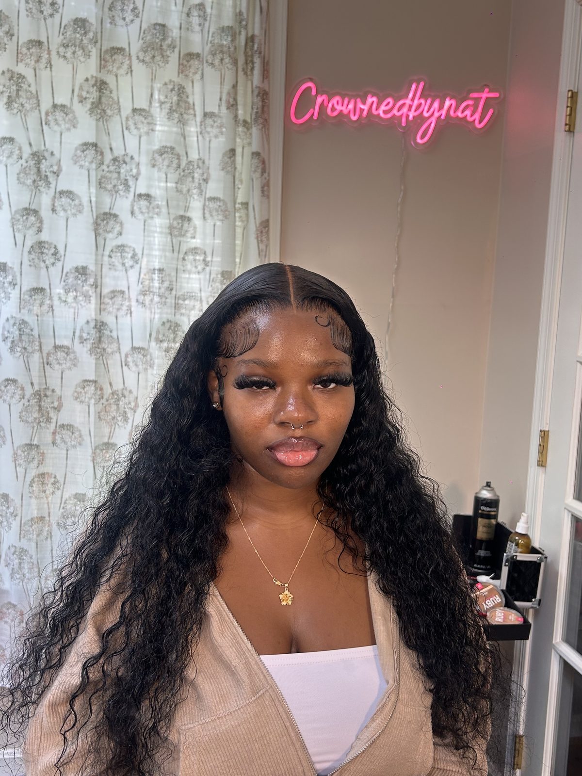 A waist-length deep-wave install parted in the centre, the lace melted flat at the parting and the edges laid in soft swirls